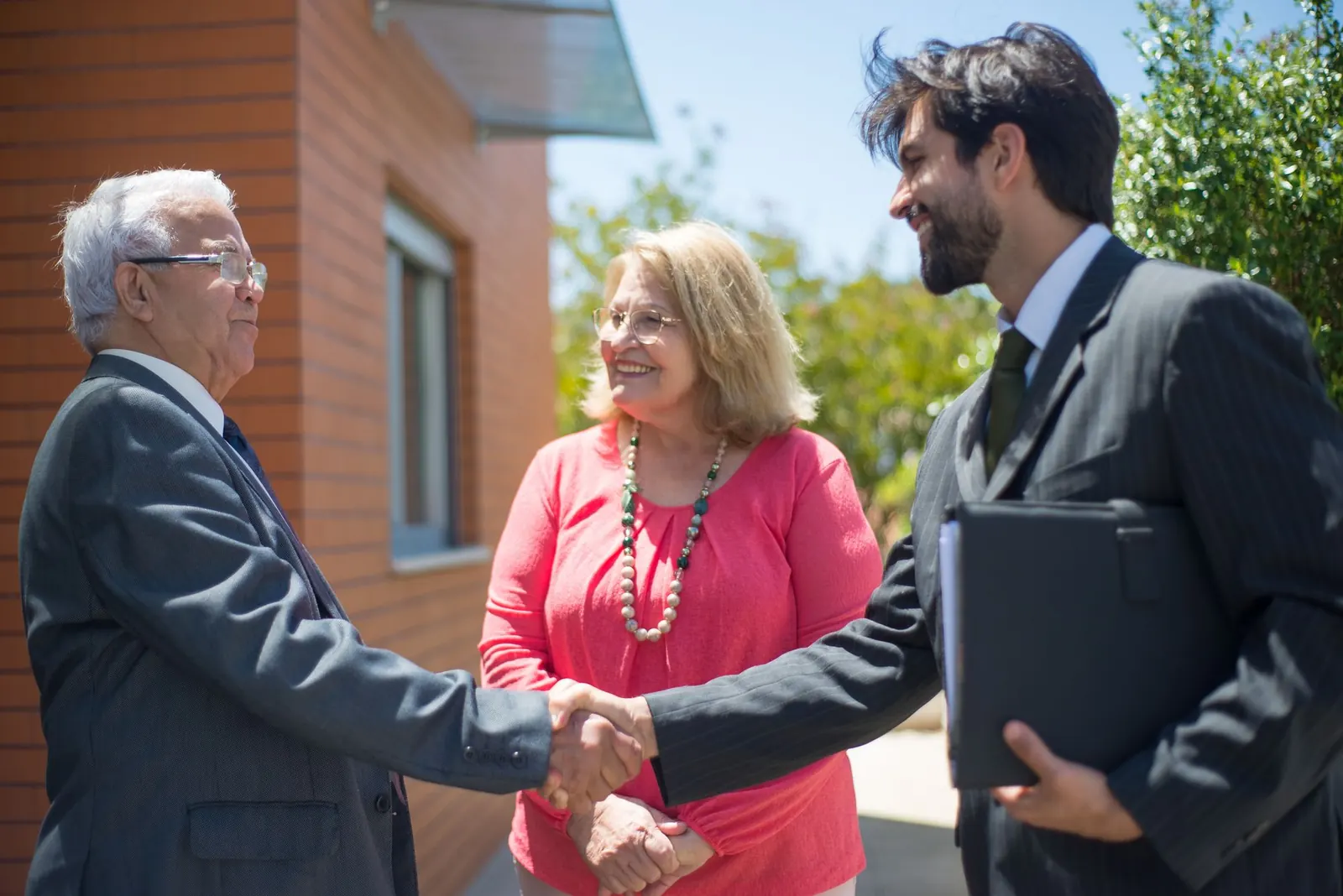 Partners greeting each other with a handshake outdoors