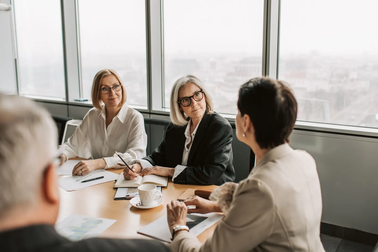 Senior colleagues discussing plans around a meeting table