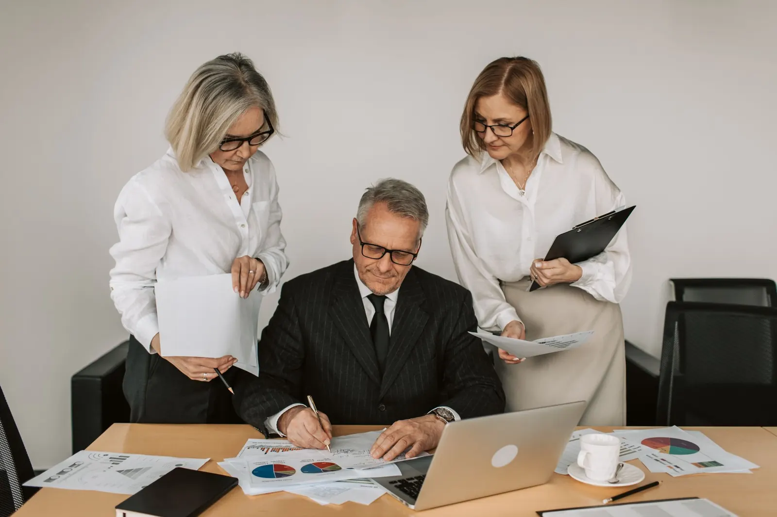 A team reviewing and signing documents together