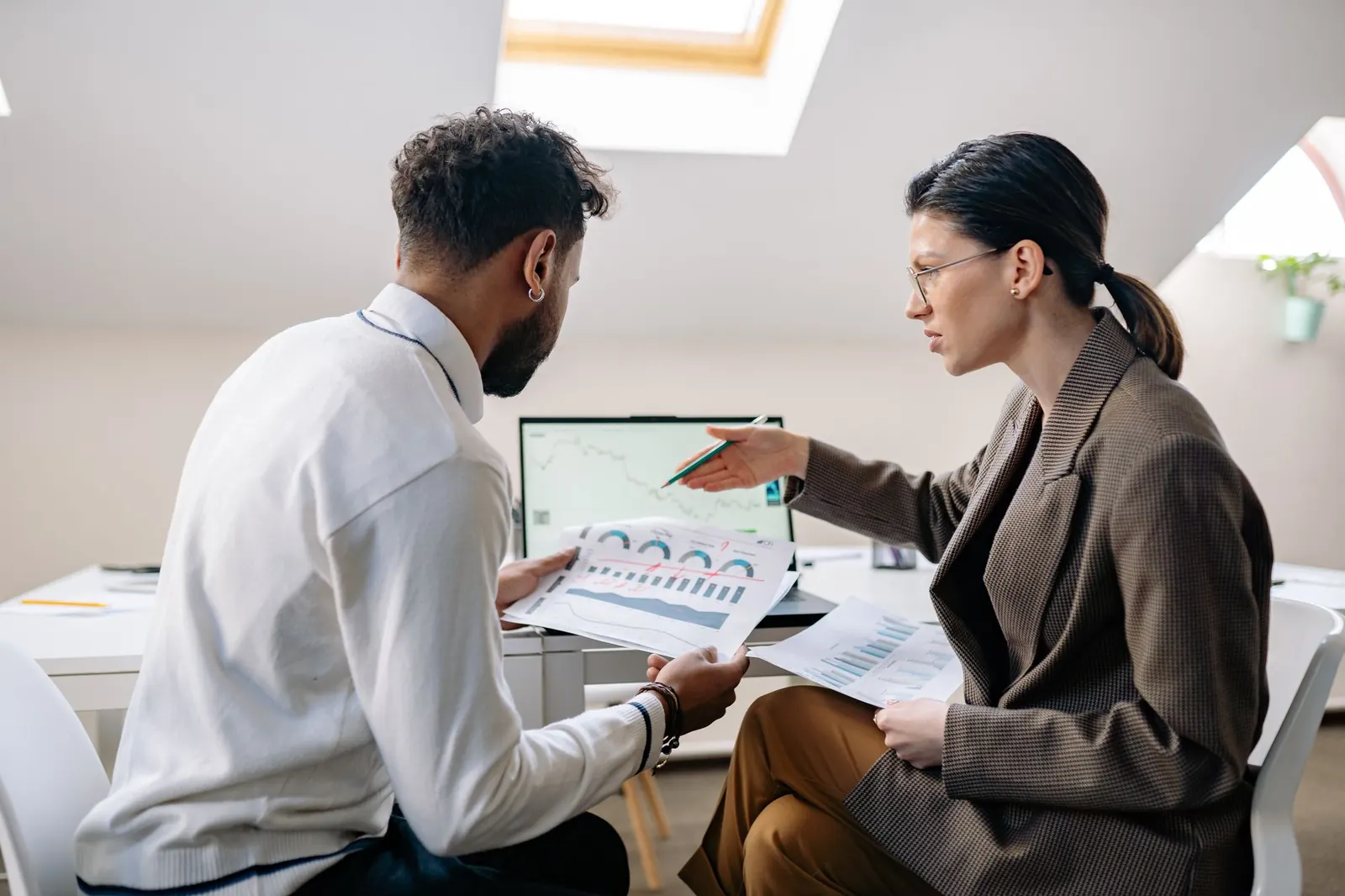 A colleague presenting a report to a teammate at a desk
